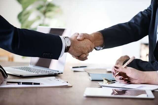 Two people shaking hands in a business meeting.