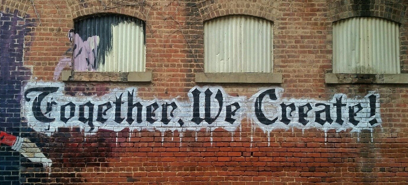 Graffiti saying “Together, we create”
